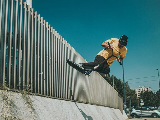 Rider di monopattino freestyle su un elemento urbano